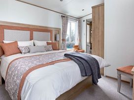 A bedroom with a bed and window at 2 Bed Lodge Sleeps 4 - Pet Welcome - Fireplace Cirencester
