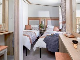 A bedroom with two beds and a mirror at 2 Bed Lodge Sleeps 4 - Pet Welcome - Fireplace Cirencester
