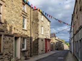 A street with stone buildings and pennant flags at Sedbergh Penthouse - KingBed - Tv - Wifi, Sedbergh