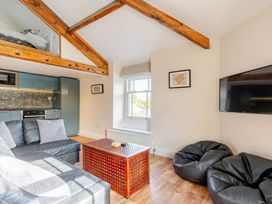 A living room with a sofa, coffee table, and television at Sedbergh Penthouse - KingBed - Tv - Wifi in Sedbergh