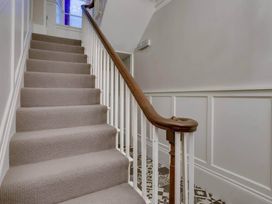 A staircase with carpet and a wooden handrail at Sedbergh Penthouse - KingBed - Tv - Wifi in Sedbergh