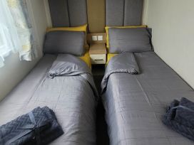 A bedroom with two beds and a bedside table at Beachside Lodge - Sleeps 6 - Pets ok - Parking Heysham
