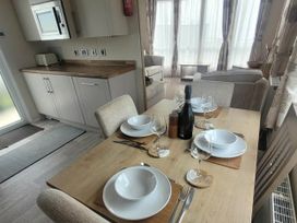 A dining room with a table set for four at Beachside Lodge - Sleeps 6 - Pets ok - Parking Heysham