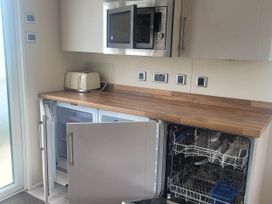 A kitchen with a fridge, dishwasher, microwave, and toaster at Beachside Lodge - Sleeps 6 - Pets ok - Parking in Heysham