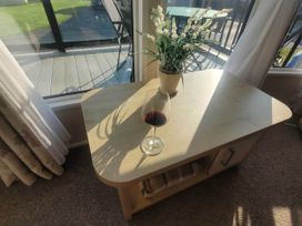 A living room with a table, wine glass, and artificial plant at Beachside Lodge - Sleeps 6 - Pets ok - Parking in Heysham