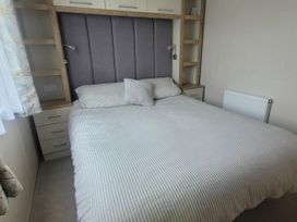 A bedroom with a bed and bedside storage at Beachside Lodge - Sleeps 6 - Pets ok - Parking Heysham