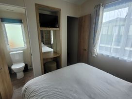 A bedroom with a bed and a toilet in the corner at Beachside Lodge - Sleeps 6 - Pets ok - Parking Heysham