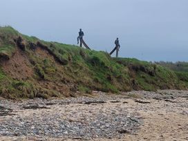 Two statues on a grassy hill at the beach