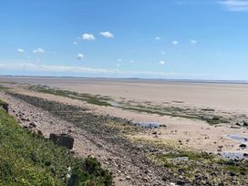 A beach view with rocks and water at Beachside Lodge - Sleeps 6 - Pets ok - Parking Heysham