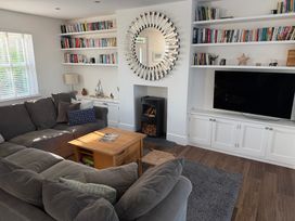 A living room with a sofa and bookshelf at Lorrell in Salcombe
