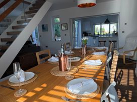 A dining room with a set table and stairs at Lorrell in Salcombe