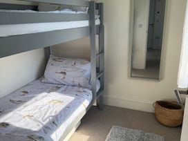 A bedroom with a bunk bed and mirror at Lorrell in Salcombe