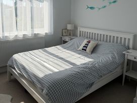 A bedroom with a bed and bedside table at Lorrell in Salcombe