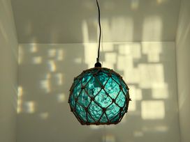 A hanging light with a glass shade at Lorrell in Salcombe