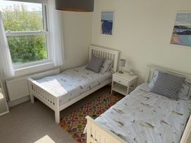 A bedroom with two beds and a window at Lorrell in Salcombe