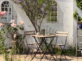 A garden with a table and chairs surrounded by flowers at Lorrell in Salcombe