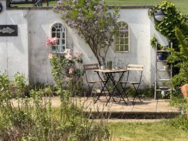A garden with a table and chairs near the wall at Lorrell in Salcombe