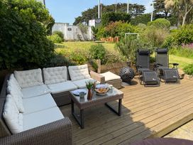 A garden with outdoor seating and lounge chairs at Lorrell in Salcombe