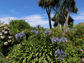 A garden with flowers and palm trees at Lorrell in Salcombe