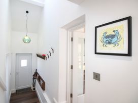 A hallway with a door and wall art at Lorrell in Salcombe