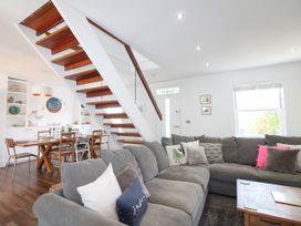 A living room with a staircase and dining area at Lorrell in Salcombe