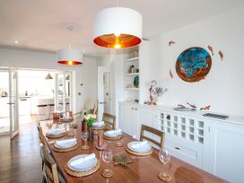 A dining room with a table set for a meal at Lorrell in Salcombe