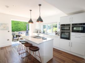 A kitchen with an island and bar stools at Lorrell in Salcombe