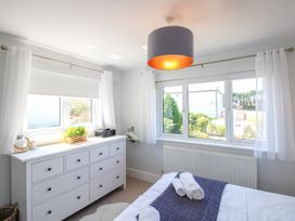 A bedroom with a bed and dresser at Lorrell in Salcombe