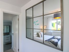 A bedroom with a bed and window viewed through a mirror at Lorrell in Salcombe