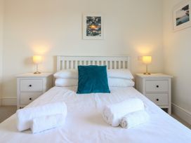 A bedroom with a bed and lamps at Lorrell Salcombe