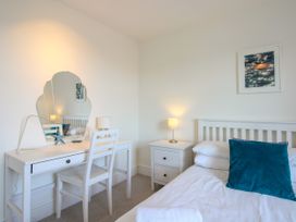 A bedroom with a bed and desk at Lorrell in Salcombe