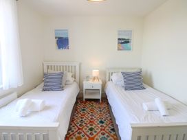 A bedroom with two single beds and a nightstand at Lorrell in Salcombe