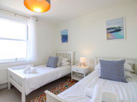 A bedroom with two beds and a bedside table at Lorrell in Salcombe