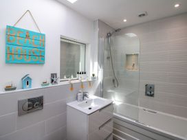 A bathroom with a bathtub and sink at Lorrell in Salcombe