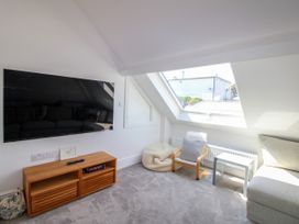 A living room with a television and sofa at Lorrell in Salcombe
