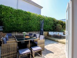 A garden with a dining table and seating area at Lorrell Salcombe