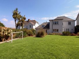 A garden with a goalpost and palm trees at Lorrell in Salcombe