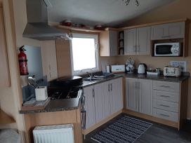A kitchen with appliances and storage at Taid's Retreat Silversands Cove beach lossiemouth