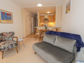 A living room with a sofa and dining area at 10 Oakley Wharf Porthmadog