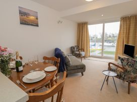 A living room with a dining table and chairs at 10 Oakley Wharf in Porthmadog