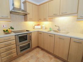 A kitchen with cabinets, oven, sink, and countertop at 10 Oakley Wharf Porthmadog