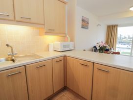 A kitchen with a sink, microwave, and cabinets at 10 Oakley Wharf Porthmadog