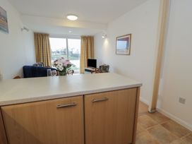 A living room with a kitchen counter and a tv at 10 Oakley Wharf in Porthmadog