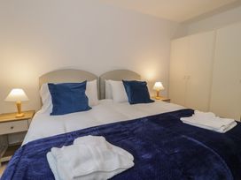 A bedroom with a double bed, bedside lamps, and wardrobe at 10 Oakley Wharf in Porthmadog