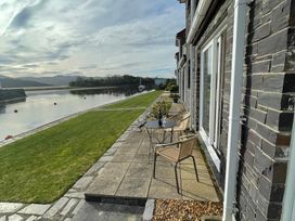 An outdoor area with a table and chairs by the water at 10 Oakley Wharf in Porthmadog
