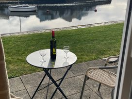 A table with a wine bottle and glasses by the water at 10 Oakley Wharf Porthmadog