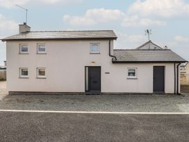 A house with two doors and multiple windows at Kiloran in Rhosneigr