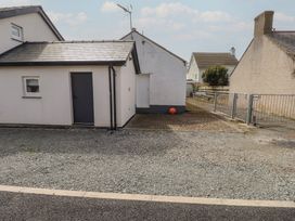 An exterior view of a house with a gravel area and a ball at Kiloran Rhosneigr