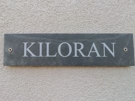 A nameplate with Kiloran displayed on a textured wall