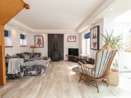 A living room with a sofa, television, and armchair at Kiloran in Rhosneigr
